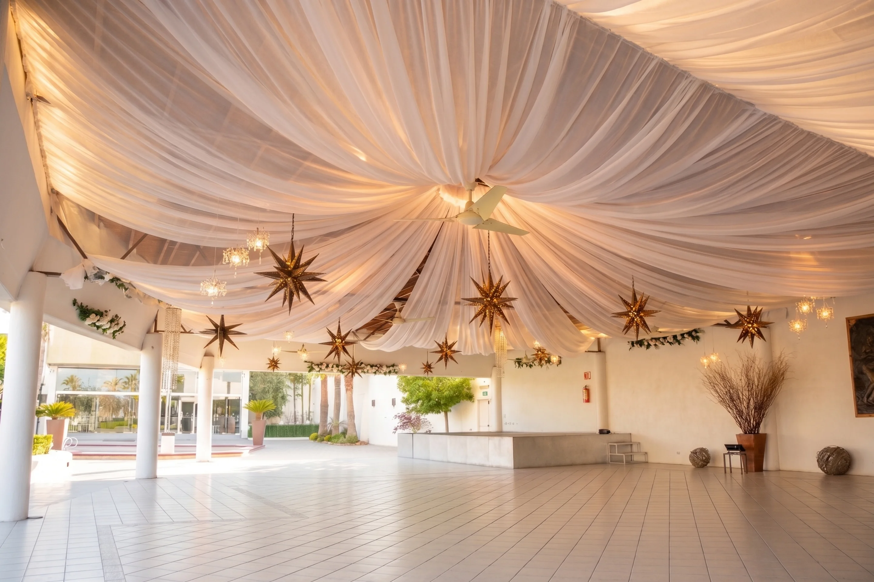 Salón de eventos con telas drapeadas y estrellas decorativas en Hacienda de Samotracia.